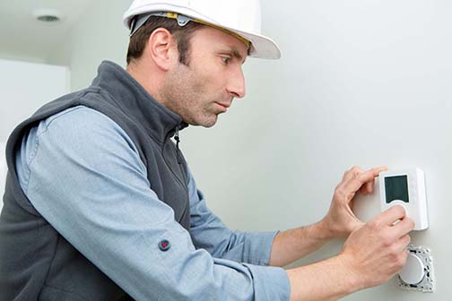 Worker installing smart thermostat